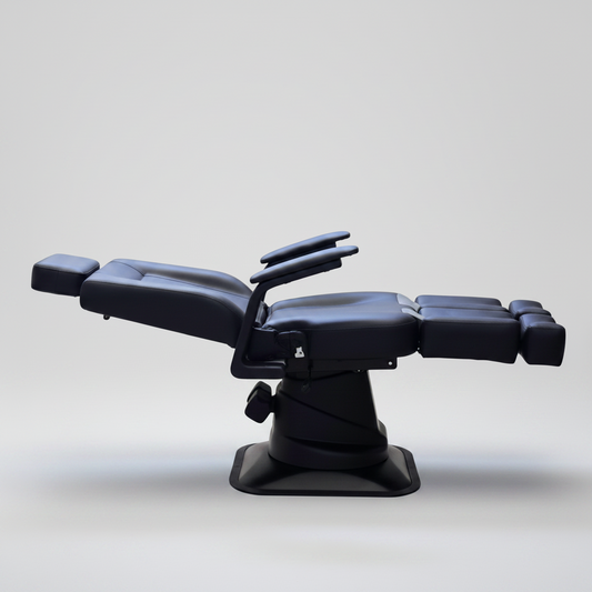 Black leather reclining massage or treatment chair with adjustable headrest, armrests, and extended footrest, shown on a plain white background.