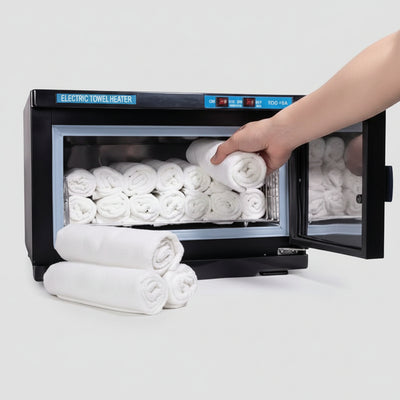 Electric towel heater with white towels inside, hand reaching in to grab a towel.