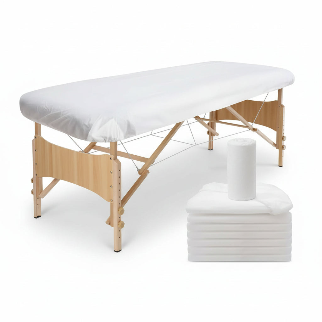 White stretch massage table cover shown on a folding massage table, with a stack of folded covers and a circular inset showing the fabric texture.